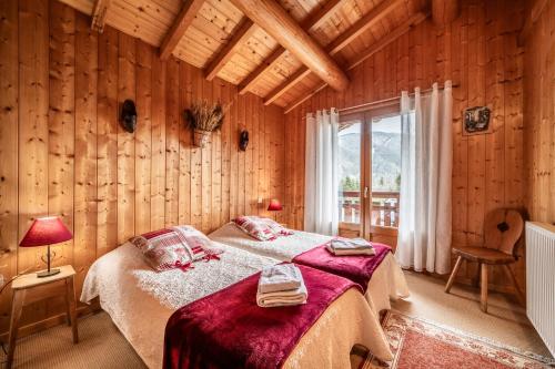 une chambre avec un lit dans une pièce aux murs en bois dans l'établissement Chalet 3 Etoiles - Le pèlouêt, à Morzine