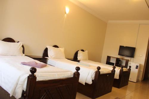 فندق سرر المحمديه الرياض في الرياض: غرفة فندقية بسريرين وتلفزيون