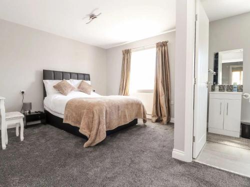 a bedroom with a bed and a large window at Beachside in Prestatyn
