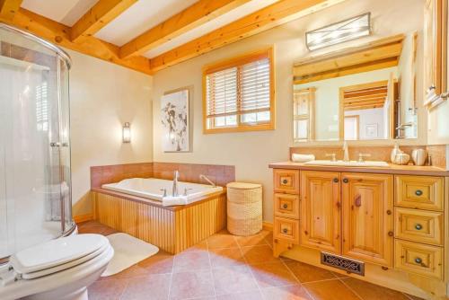 Val des Monts的住宿－The Vista - Magnificent waterfront beach & hot tub，带浴缸、卫生间和盥洗盆的浴室