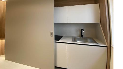a small kitchen with a sink and white cabinets at Amatera Luxury Apartments in Matera