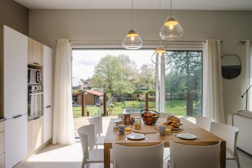 a dining room with a table and a large window at le 47, une pause à la campagne in Duisans