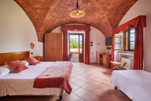 グアルディスタッロにあるHotel Fattoria Belvedereの広いベッドルーム(ベッド2台、暖炉付)
