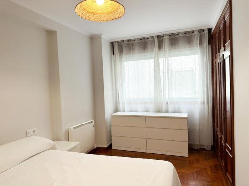een slaapkamer met een bed en een raam bij Piso en el centro de Vigo 2 dormitorios Brasil in Vigo