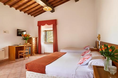 a bedroom with a bed and a desk with flowers on it at Hotel Fattoria Belvedere in Guardistallo