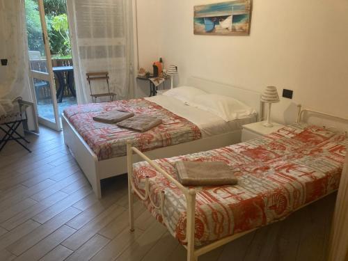 Un dormitorio con 2 camas y una silla. en GUEST HOUSE BERZEFI, en Bergeggi
