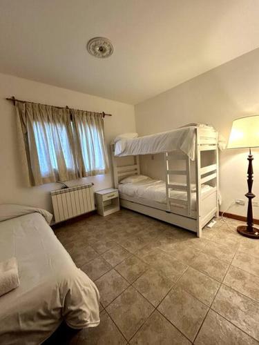 a bedroom with a bunk bed and a lamp at Casa en Bosque de Pinos in San Carlos de Bariloche