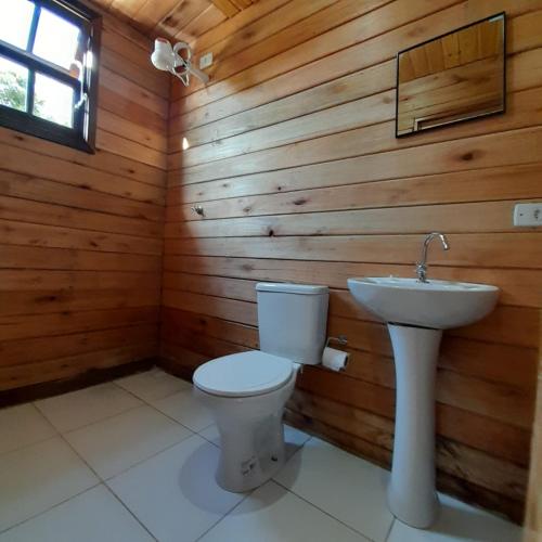 a bathroom with a toilet and a sink at Chalé Ubatuba in Ubatuba