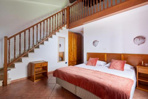 a bedroom with a bed and a staircase at Hotel Fattoria Belvedere in Guardistallo