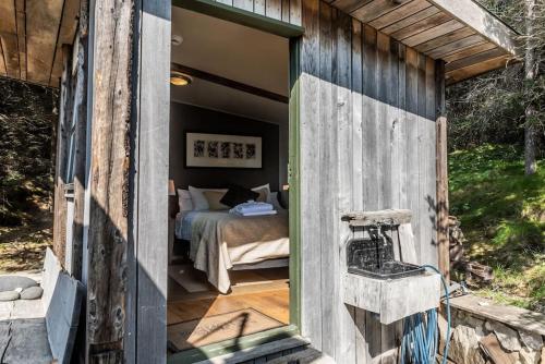 1 dormitorio con 1 cama en una habitación con ventana en Luxury Lakefront villa, infinity hot tub and sauna, en Grímsnes og Grafningshreppur
