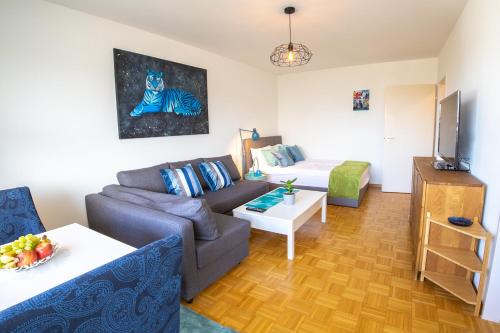 a living room with a couch and a tv at Special BLUE TIGER Apartment Basel, Messe Kleinbasel 10-STAR in Basel