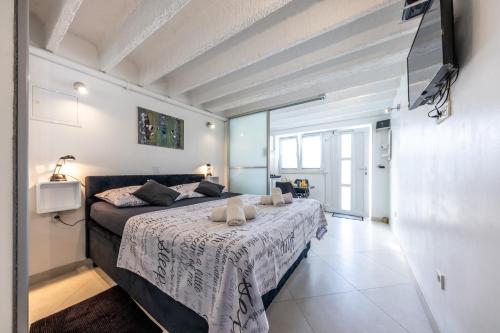 Val Apartments في دوبروفنيك: غرفة نوم مع سرير وتلفزيون على الحائط