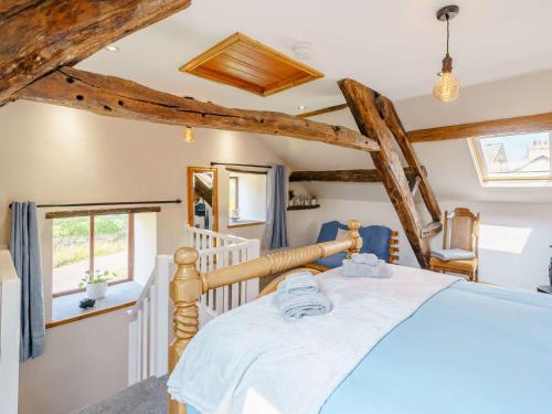 2 Bed in Ulverston 83453 في Great Urswick: غرفة نوم بسرير في غرفة عوارض خشبية