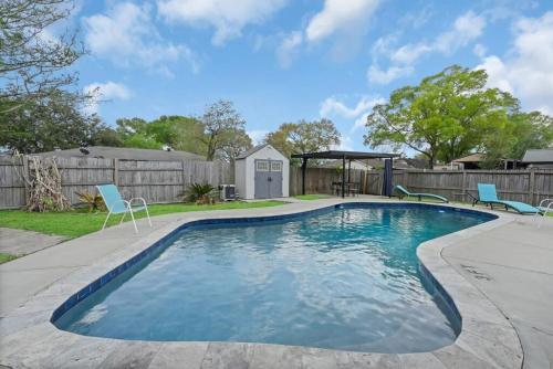 a swimming pool with chairs and a gazebo at Pool/ Outdoor kitchen/Pool table in Houston