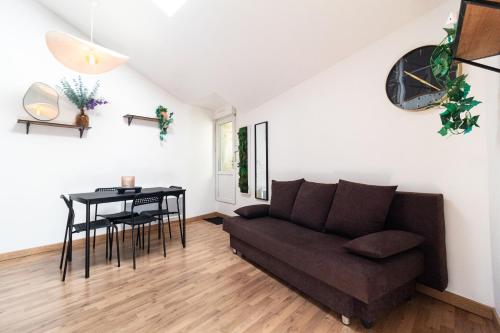 a living room with a couch and a table at Le charmant accueil viennois/T2/wifi/cosy/parking in Poitiers