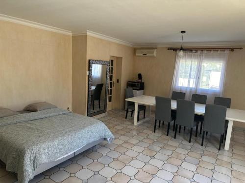 une chambre avec un lit, une table et des chaises dans l'établissement Les Bruyères, à Martigues
