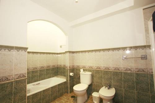 a bathroom with a toilet and a bath tub at Villa Los Morales-Roque in Cotillo