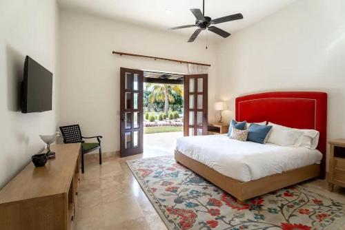 a bedroom with a large bed with a red headboard at Phenomenal Oceanview Villa in Puerto Los Cabos in San José del Cabo