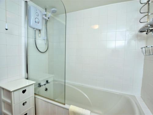 a white bathroom with a tub and a shower at 2 Bed in Aberporth 85444 in Felindre