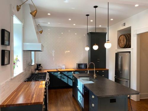 a kitchen with blue cabinets and a black counter top at DERBY LUXE 3-story Historic 6 min from Churchill in Louisville