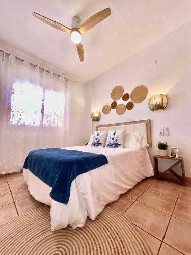 a bedroom with a large bed with a ceiling fan at SUNSET CAMBRILS in Cambrils