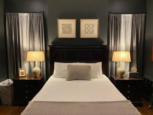 a bedroom with a large bed with two lamps at DERBY LUXE 3-story Historic 6 min from Churchill in Louisville