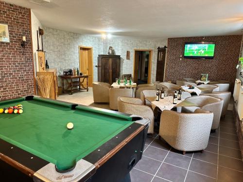 a pool table in a room with chairs and a tv at Landhotel Peters in Canow