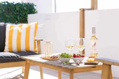 a table with food and wine glasses on a patio at Golden Stay - B&B Experience in Albufeira