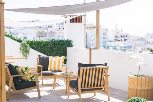 a patio with chairs and a table on a balcony at Golden Stay - B&B Experience in Albufeira