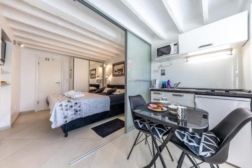 ドゥブロヴニクにあるVal Apartmentsのベッド、テーブル、椅子が備わる小さなアパートメントです。