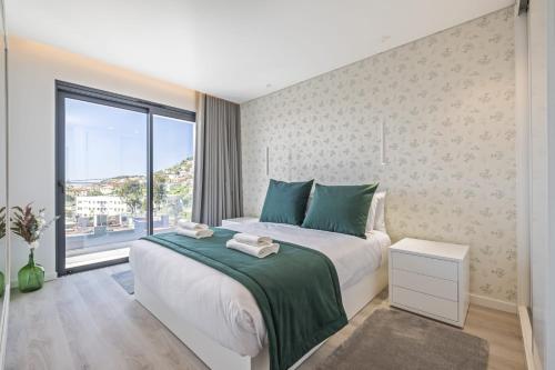a bedroom with a large bed and a large window at Contemporary Residence B by Homie in Funchal