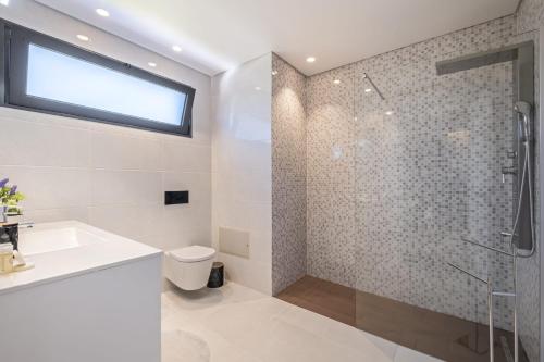 a white bathroom with a shower and a sink at Contemporary Residence B by Homie in Funchal