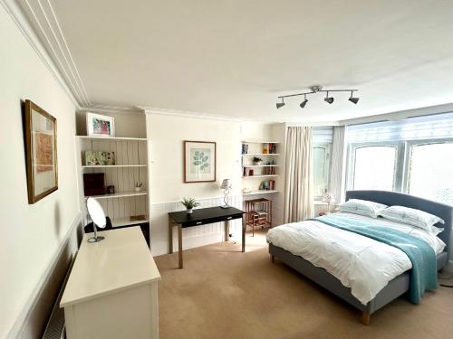 - une chambre avec un lit et un bureau dans l'établissement East Finchley N2 apartment close to Muswell Hill & Alexandra Palace with free parking on-site, à Londres
