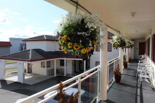 a balcony with flowers hanging from a building at BK's Rotorua Motor Lodge in Rotorua