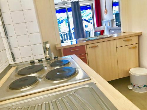 d'une cuisine équipée d'une cuisinière avec quatre plaques bleues. dans l'établissement Bel Appartement à Villard de Lans, pour 6 Personnes, Proche Commerces - FR-1-515-18, à Villard-de-Lans