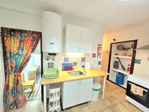una cocina con mesa y ordenador portátil. en Refúgio de Arez-Alojamento Local, en Arez
