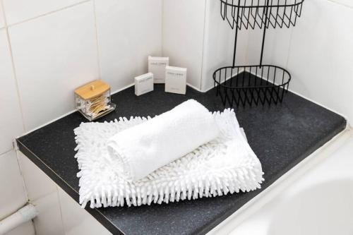 um balcão preto com toalhas brancas na casa de banho em Beautiful House by Station with Private Parking em Cambridge