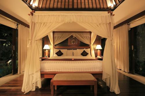 a bedroom with a bed with a canopy at The Sanyas Suite Bali in Seminyak