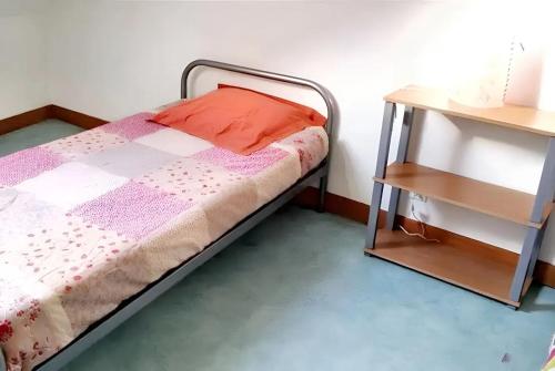 a small bedroom with a bed and a side table at Appartement confortable à Mesnay - 70 m² - Balcon privé in Mesnay