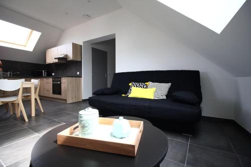 un salon avec un canapé noir et une table dans l'établissement T2 atypique, entièrement rénové, quartier Soulages, à Rodez