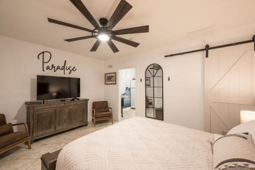 a bedroom with a bed and a flat screen tv at The Cozy Little Cottage in Key West