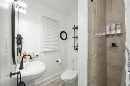 a white bathroom with a sink and a toilet at The Cozy Little Cottage in Key West