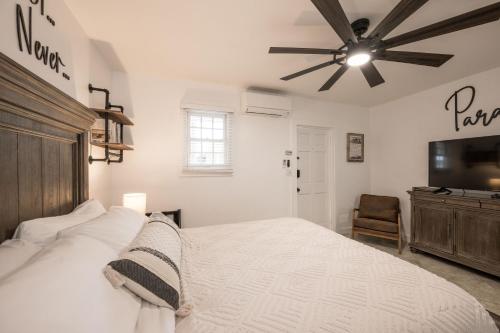 a bedroom with a bed and a ceiling fan at The Cozy Little Cottage in Key West