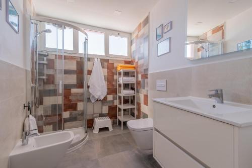 ein Badezimmer mit Waschbecken, Toilette und Dusche in der Unterkunft Villa Piña in Corralejo