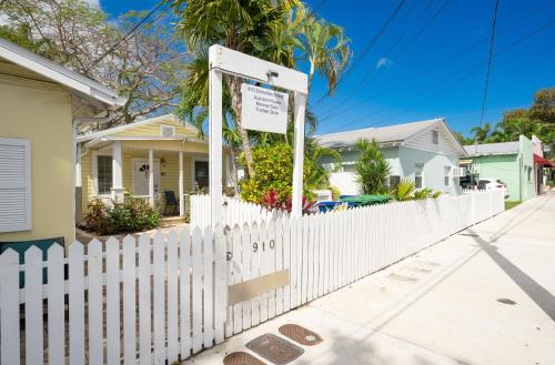 a white picket fence in front of a house at The Cozy Little Cottage in Key West