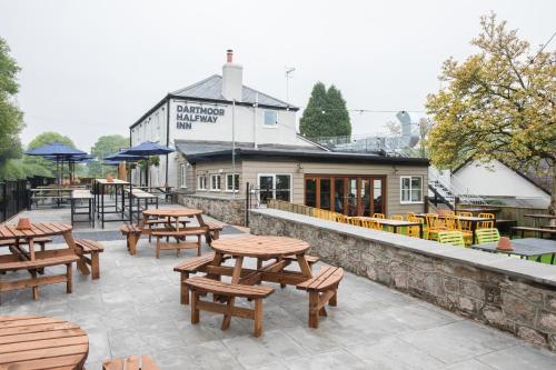 a group of tables and benches in front of a building at Dartmoor Halfway Campsite in Newton Abbot