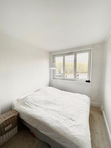 ein weißes Schlafzimmer mit einem Bett und einem Fenster in der Unterkunft Shiny apartment - Direct line to Olympic Village in Clichy