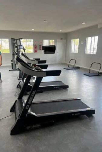 - une salle de sport avec plusieurs tapis de course dans l'établissement Apartamento Oásis Itú, à Itu