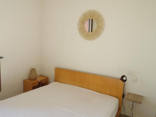 une chambre avec un lit et un miroir au mur dans l'établissement St Cyprien maison 4 personnes 200m de la plage, à Saint-Cyprien