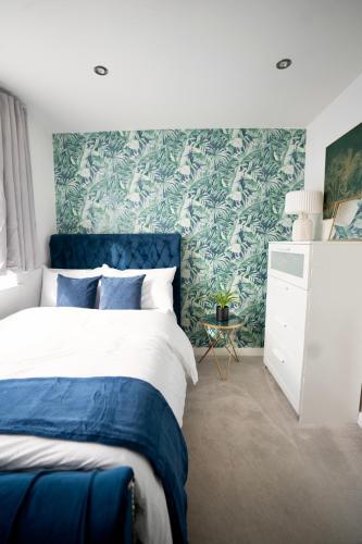 盧頓的住宿－Luxury 2 Bed Apartment in Town Centre - FREE WIFI!!，卧室设有蓝色和白色的床和绿色的墙壁